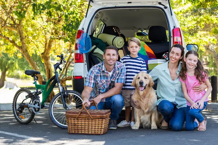 Family with dog getting ready for road trip